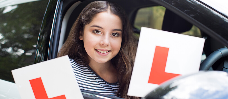 girl holding learner plates