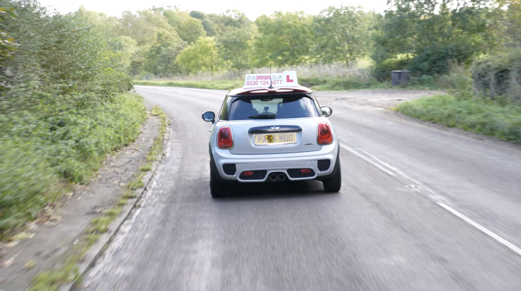 driveJohnson's mini driving on a road